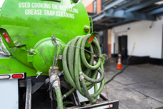 a technician pumping a grease trap in a commercial building in Cedar Bluff